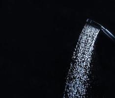 Running shower faucet on a dark background photo