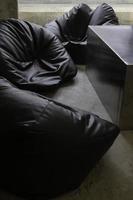 Black bean bag chair around a table photo