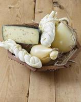 Different types of cheeses on a wooden background photo