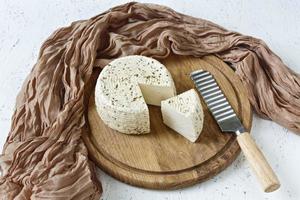 White cheese on a wooden board on a white background photo