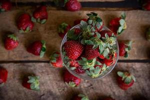 Strawberries in a glass and on a table photo