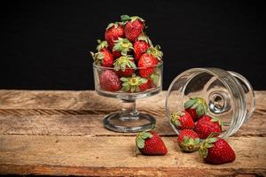 Strawberries in a glass on a wooden table