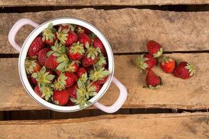 Fresas en un recipiente sobre una mesa de madera foto