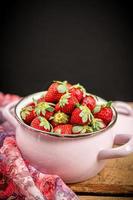 Strawberries in a bowl on a wooden table