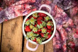 Strawberries in a bowl on a wooden table photo