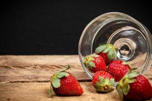 fresas en un vaso sobre una mesa de madera foto