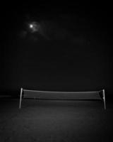 Campo de voleibol solitario en una playa en una noche de luna foto