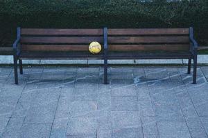 Soccer ball on a wooden bench on the street photo