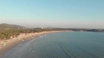 kustlijn die zich uitstrekt over de horizon met vissersboten afgemeerd aan het gouden zand, palolem beach