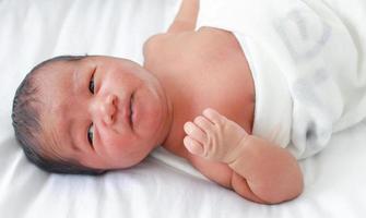 Bebé recién nacido masculino en una cama de hospital foto