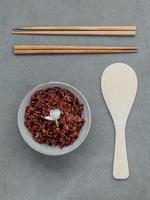Top view of rice with chopsticks and wooden utensil photo