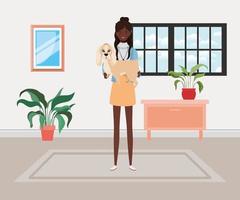 young afro woman lifting cute dog indoors