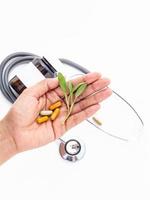 Herbal pills and stethoscope with hand photo