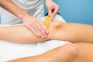 Kinesio taping knee application of a physiotherapist photo