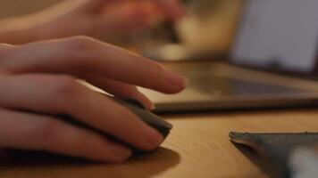 Close up of hands of young Middle Eastern man using computer mouse and typing on laptop video