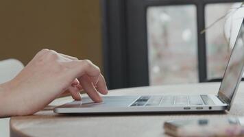 Close up of hand of young mixed race woman, scrolling on touchpad of laptop video