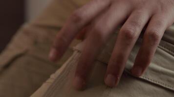 Close up of fingers of young Middle Eastern man tapping on lap, close up of the man with headphone smiling video