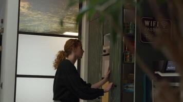 White young woman busy searching in kitchen, looks around, points, thinks, hand on mouth, looking contemplatively video