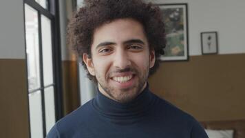 Close up of young Middle Eastern man, standing, looking into camera, laughing video