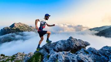 Corredor de ultramaratón masculino en las montañas durante un entrenamiento foto