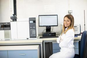 Female scientist in white lab coat sitting in the biomedical lab photo