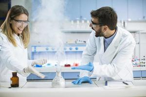 Investigadores que realizan experimentos con humo en una mesa de un laboratorio químico. foto