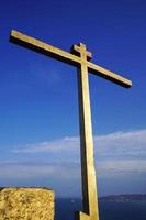 A golden metal cross with a cloudy blue sky in Vladivostok, Russia photo