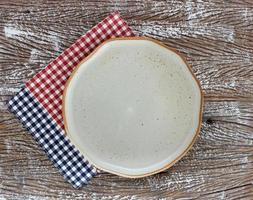 Top view of an empty ceramic plate with napkins on a wood table background photo