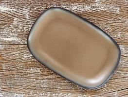 Top view of an empty ceramic plate on a wood table background photo