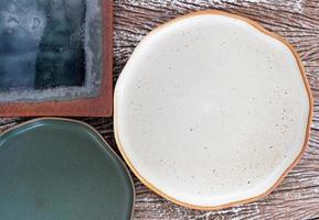 Top view of empty ceramic plates on a wood table background photo