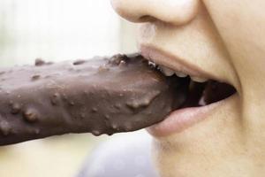 mujer comiendo una barra de chocolate foto