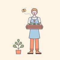 A man in an apron standing with a wooden box of flowers vector