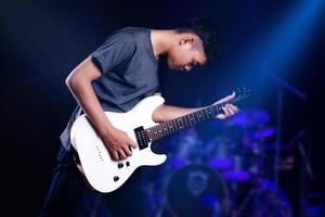 Young man with electric guitar in studio photo