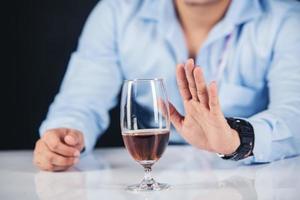 Handsome man drinking whisky at home photo