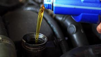olio sintetico che viene versato nel motore dell'auto