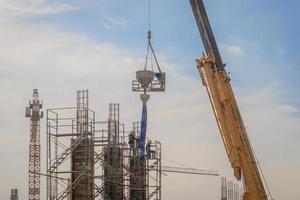 Trabajadores de la construcción que trabajan en andamios de alto nivel. foto