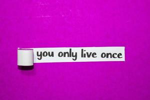 You only live once text, Inspiration, Motivation and business concept on purple torn paper photo