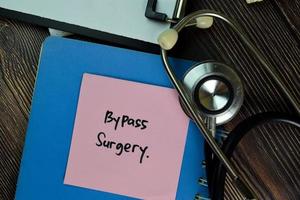 Bypass Surgery written on a paperwork isolated on wooden table photo