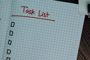 Task List written in a book isolated on wooden table photo