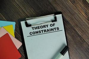 Theory Of Constraints written on paperwork isolated on wooden table photo