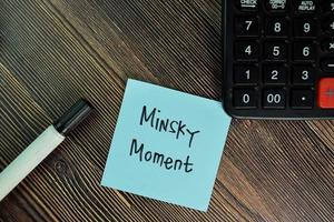 Minsky Moment written on sticky note isolated on wooden table photo