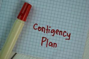 Contingency Plan written on sticky note isolated on wooden table photo