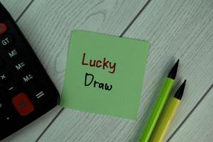 Lucky Draw written on sticky note isolated on wooden table photo