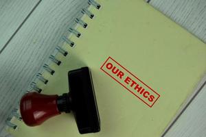 Red handle rubber stamper and Our Ethics text isolated on table photo