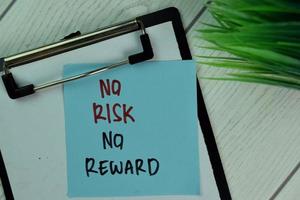 No Risk No Reward written on sticky note isolated on wooden table photo