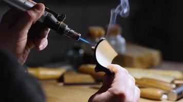 worker burns a wooden tea stand with a burner video