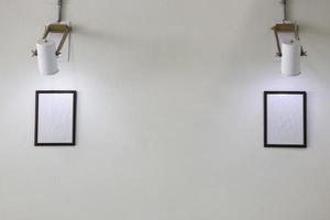 Two empty picture frames on white wall photo