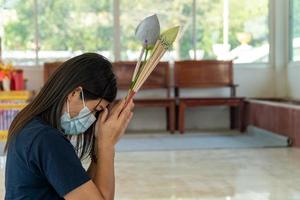 Joven mujer asiática pidiendo un deseo en un templo, concepto de vida, esperanza, fe y buena suerte foto