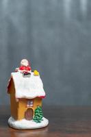 Miniature Santa Claus sitting on a roof, Christmas legend and Happy Holidays concept photo