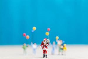 Miniature Santa Claus and children holding balloons, Merry Christmas and Happy New Year concept photo